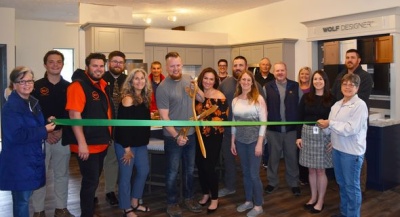 BILT Construction's Tim Reed, Sarah Reed, Lora Sevigny, and numerous guests participating in the ribbon cutting ceremony for BILT Construction's new showroom.