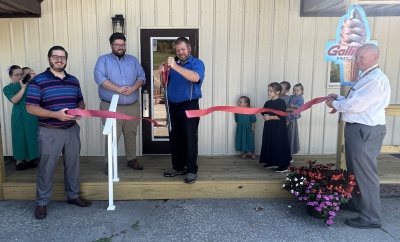 New Germany Store owner Harold Schrock cuts the ribbon during a ceremony on Sept. 20th as several of his children watch. With the ribbon (l-r): Nick Sharps of the Garrett County Chamber of Commerce, Connor Norman of Garrett County Business Development, Harold Schrock, and Garrett County Commissioner Paul Edwards. Photo credit: Brenda Ruggiero, The Garrett County Republican.