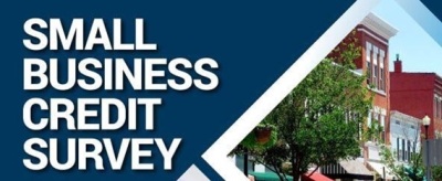 Small Business Credit Survey - white text on a navy background; photo of buildings on the right side of the graphic