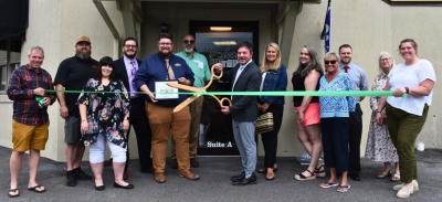 Men and women celebrating the ribbon cutting for Blair's By The Lake.