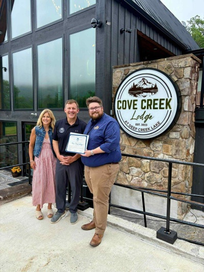 Connor Norman presents milestone proclamation to Cove Creek Lodge.