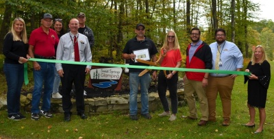 Men and women celebrating the grand opening of Sweet Springs Glamping. Photo credit Garrett County Chamber of Commerce