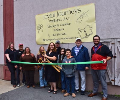Men and women celebrating the ribbon cutting for Joyful Journeys Wellness, LLC.