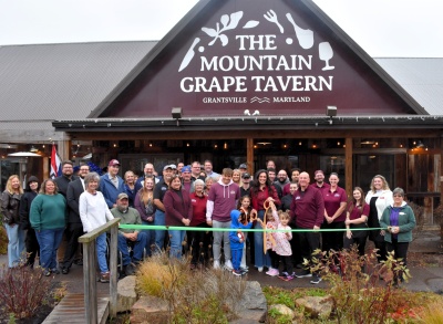 Men and women celebrating the ribbon cutting for The Mountain Grape Tavern in Grantsville.