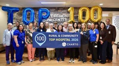 GRMC staff posting in the hospital with a Top 100 award banner