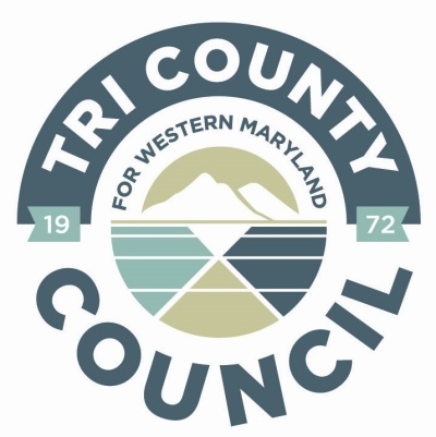 Logo - Tri-County Council for Western Maryland. The logo depicts the 3 counties working and moving forward together. The mountains accurately depict the worn Appalachian Mountains which is tied to our identity within Maryland and link us to our peer Appalachian communities in the ARC region. The badge also features the founding date of TCCWMD - 1972 - demonstrating the longevity of the organization and work we do. The color palette is comprised of neutral earth tones.
