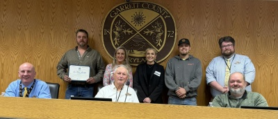 Photo (l-r) Front Row: Garrett County Commissioners Paul Edwards, Larry Tichnell, and Connor Norman. Back Row (l-r): Jeff Thomas, Denise Thomas, Quinn Thomas, and Alden Layman of Iron Horse Associates, and Business Development Specialist Connor Norman. Front Row, Commissioner Paul Edwards, Commissioner Larry Tichnell, Commissioner Ryan Savage. 