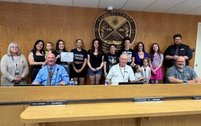 Photo: Back Row - Manager of Business Development Kim Durst, cosmic Studios representatives Julia Spitznogle holding John Spitznogle, Natalie Hooks, Madisun Thompson, Natalie Spitznogle, Alyssa Hooks, Madison Hinebaugh, Alyvia Spitznogle, Emily Hinebaugh, Christi Hinebaugh, and Kaitlin Shaffer, and Business Development Specialist Connor Norman. Front Row - Commissioner Paul Edwards, Commissioner Larry Tichinell, Commissioner Ryan Savage.