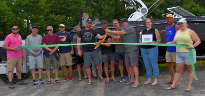 Photo: Men and women cutting the ribbon to celebrate the grand opening of Next Level Marine in Oakland, MD.